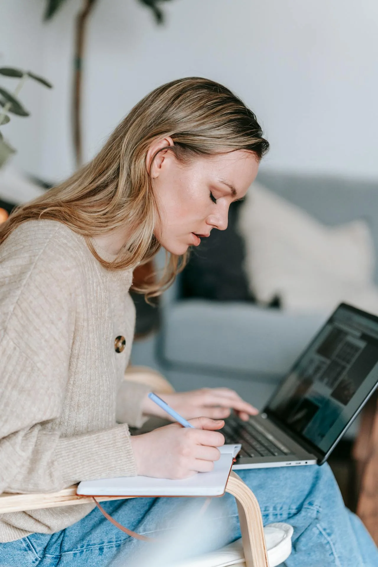 Student working with laptop and writing notes in planner
