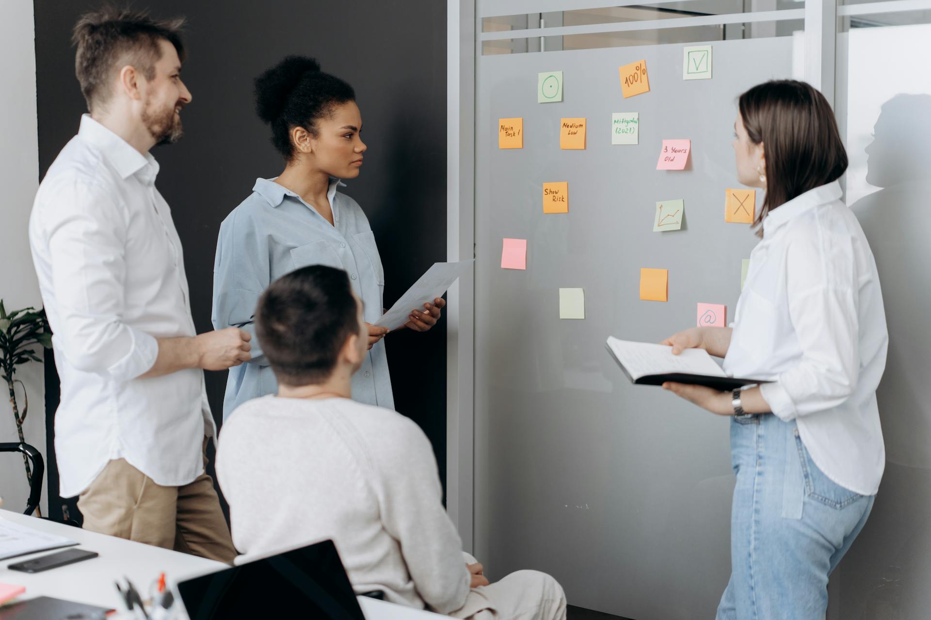 Team brainstorming with colorful sticky notes on glass wall during page structure planning